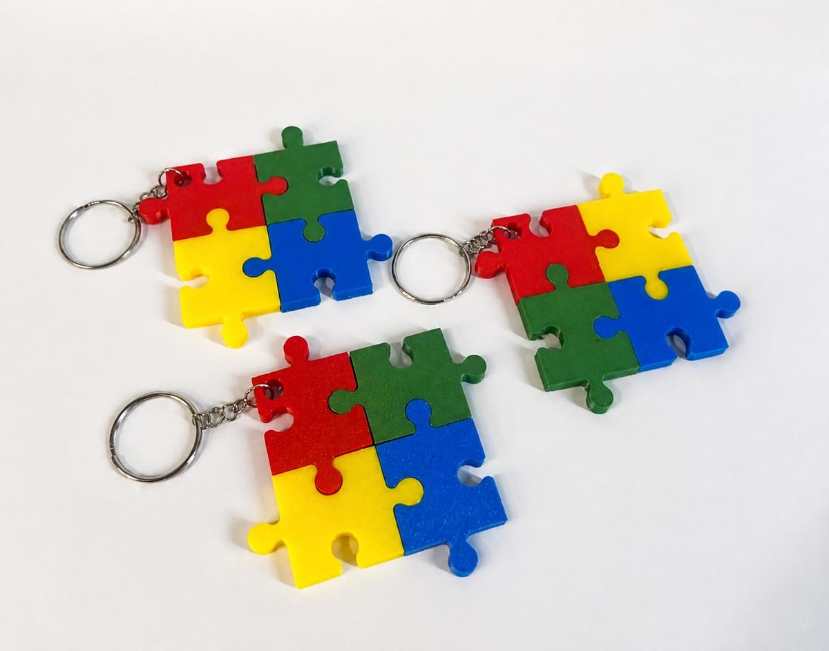 Three multicolour interlocking puzzle-piece keyrings photographed by a MakerWorld user after printing the design