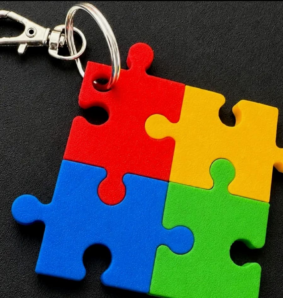 Close view of the interlocking red, yellow, blue and green printed keyring showing the surface texture and fitted joints